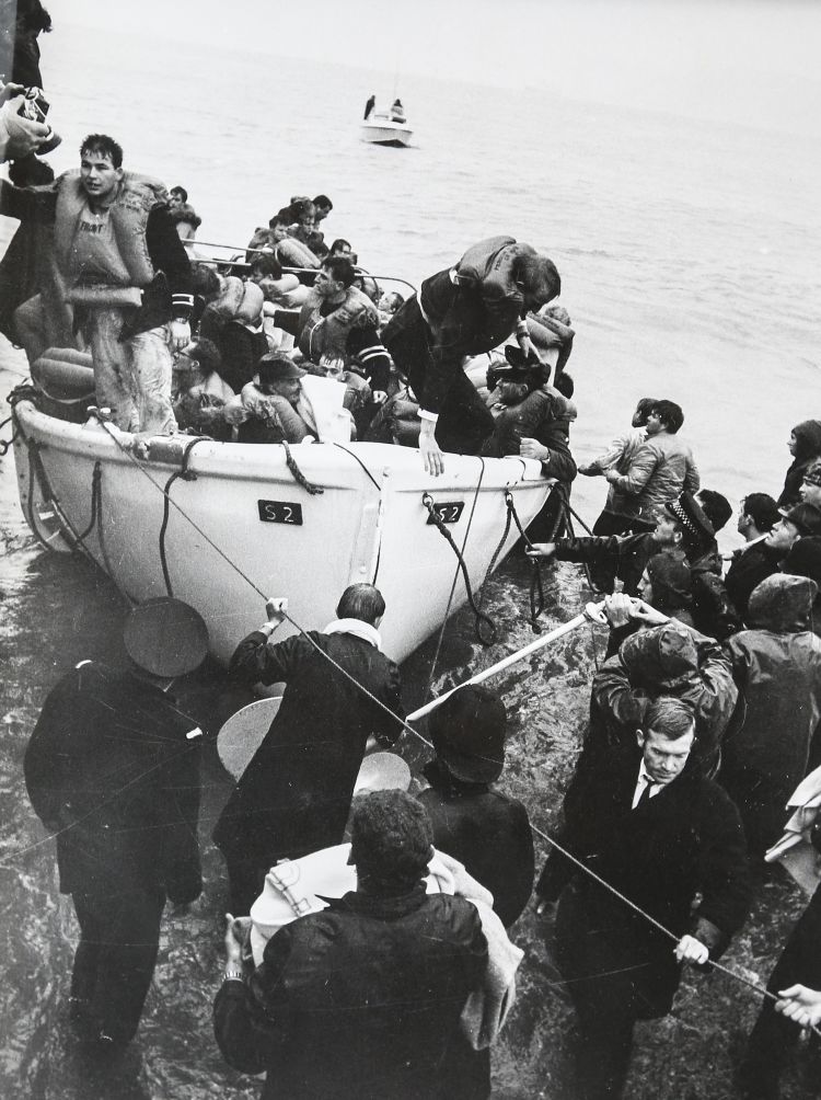 Lifeboat number S2 is brought ashore at Seatoun beach. Lifeboat skipper Phil Bennett is top left. Brian Papesch is standing in the middle of the boat, wearing a black jersey with two white stripes on the sleeve. THE DOMINION POST