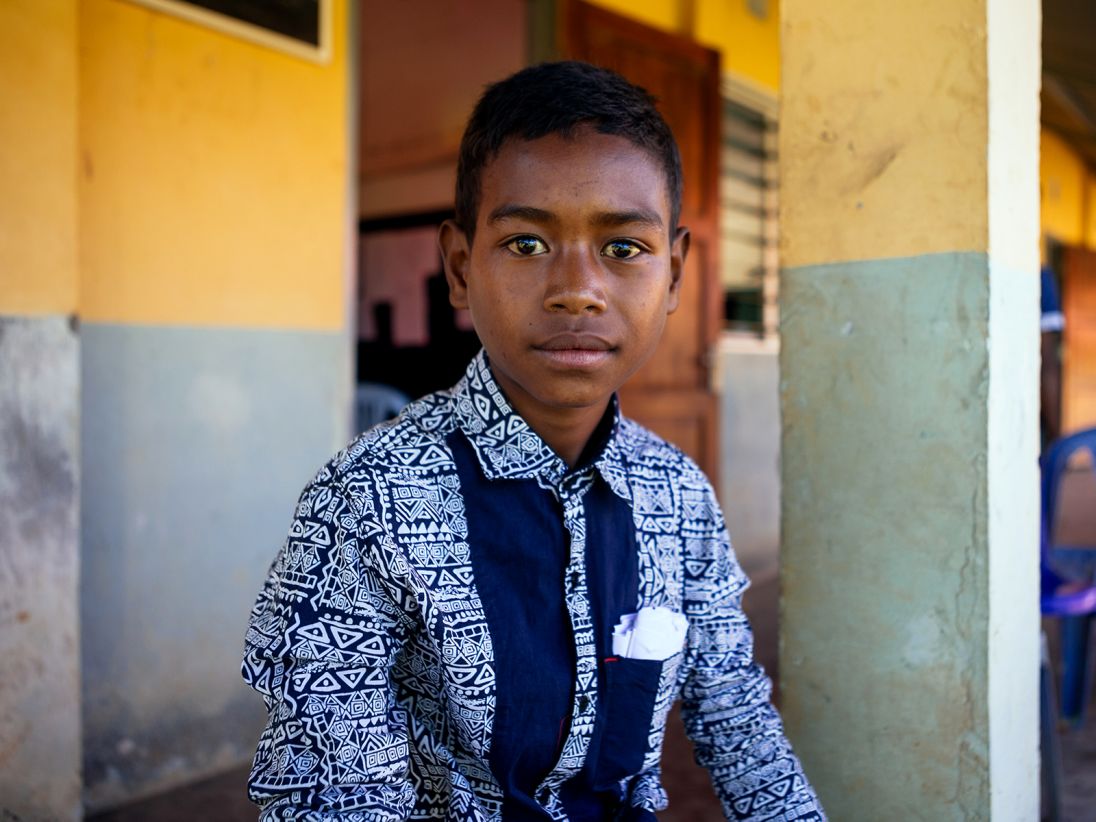 Joao Adison Tapel is one of the children who walks an hour and a half in each direction to help collect water.