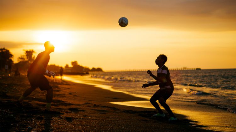 Men practising balla on the beach in Dili