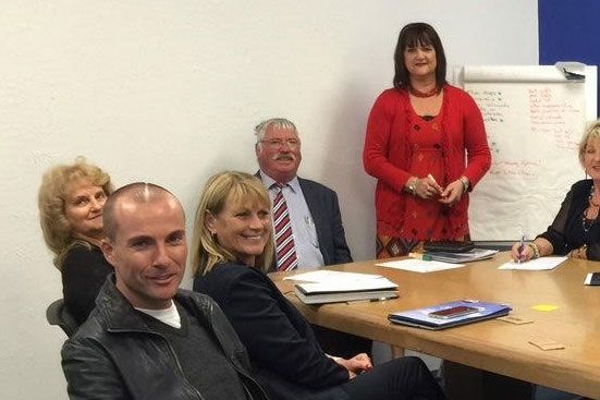 Corrina Mansell, standing, is flanked by Andrew Gibson during a lecture with real estate agents. Cary Ralph is at front.