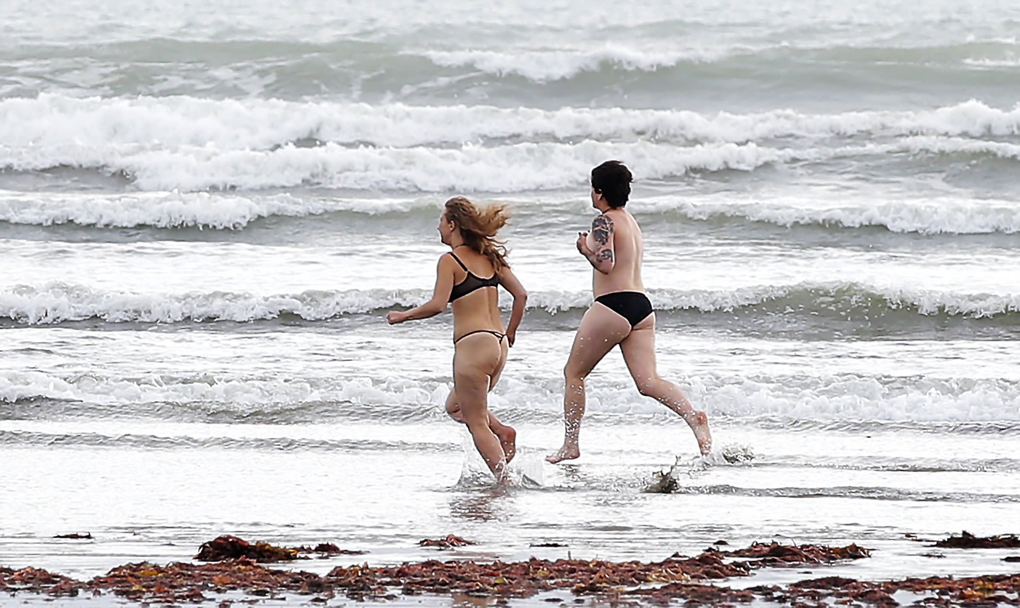 Russian group Pussy Riot visits Invercargill ahead of their concert on Monday night. Pictured Maria "Masha" Alyokhina, left, and Shannon run into the surf at Oreti beach, Invercargill, for a swim.