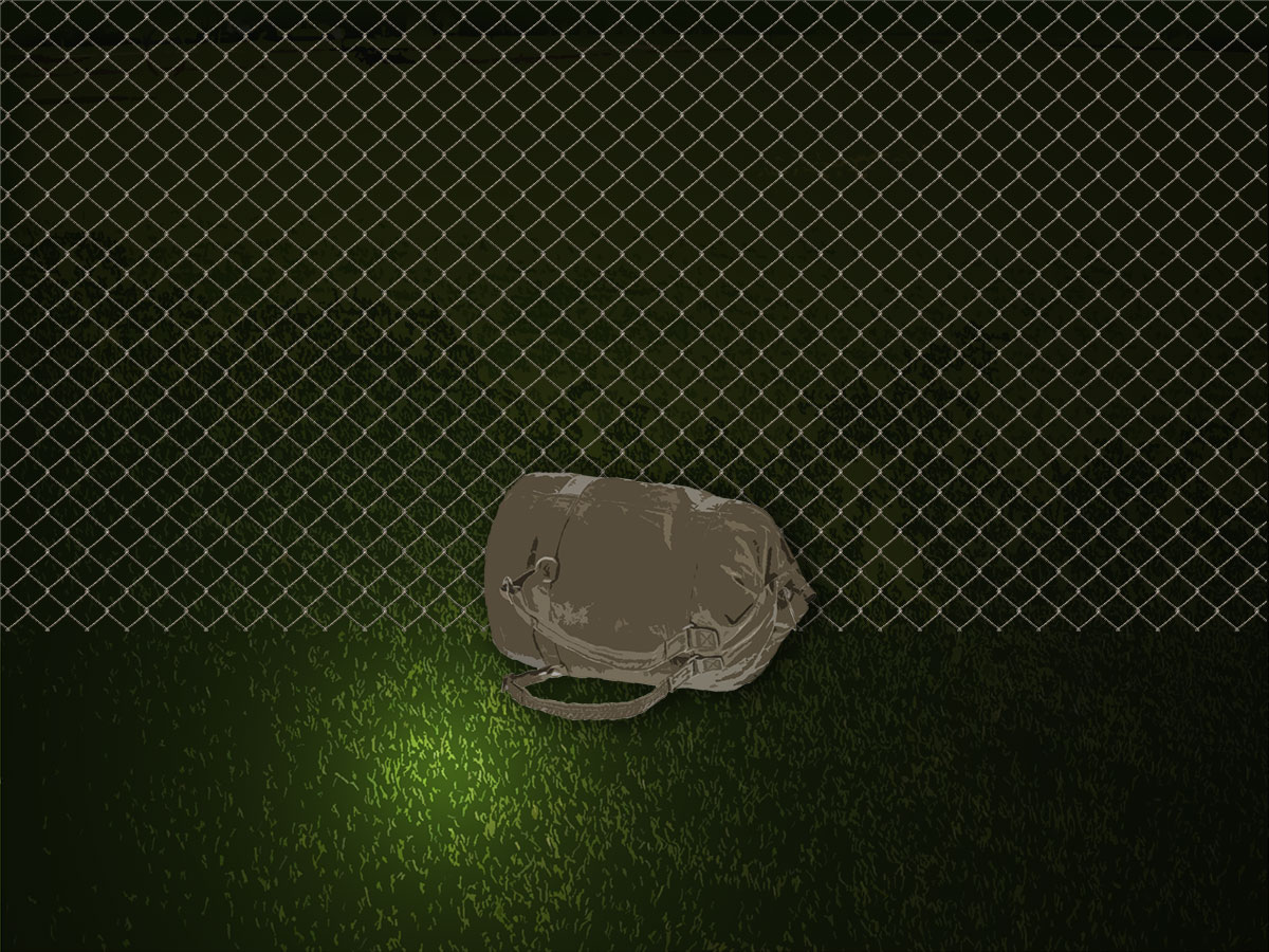 duffle bag by wire fence