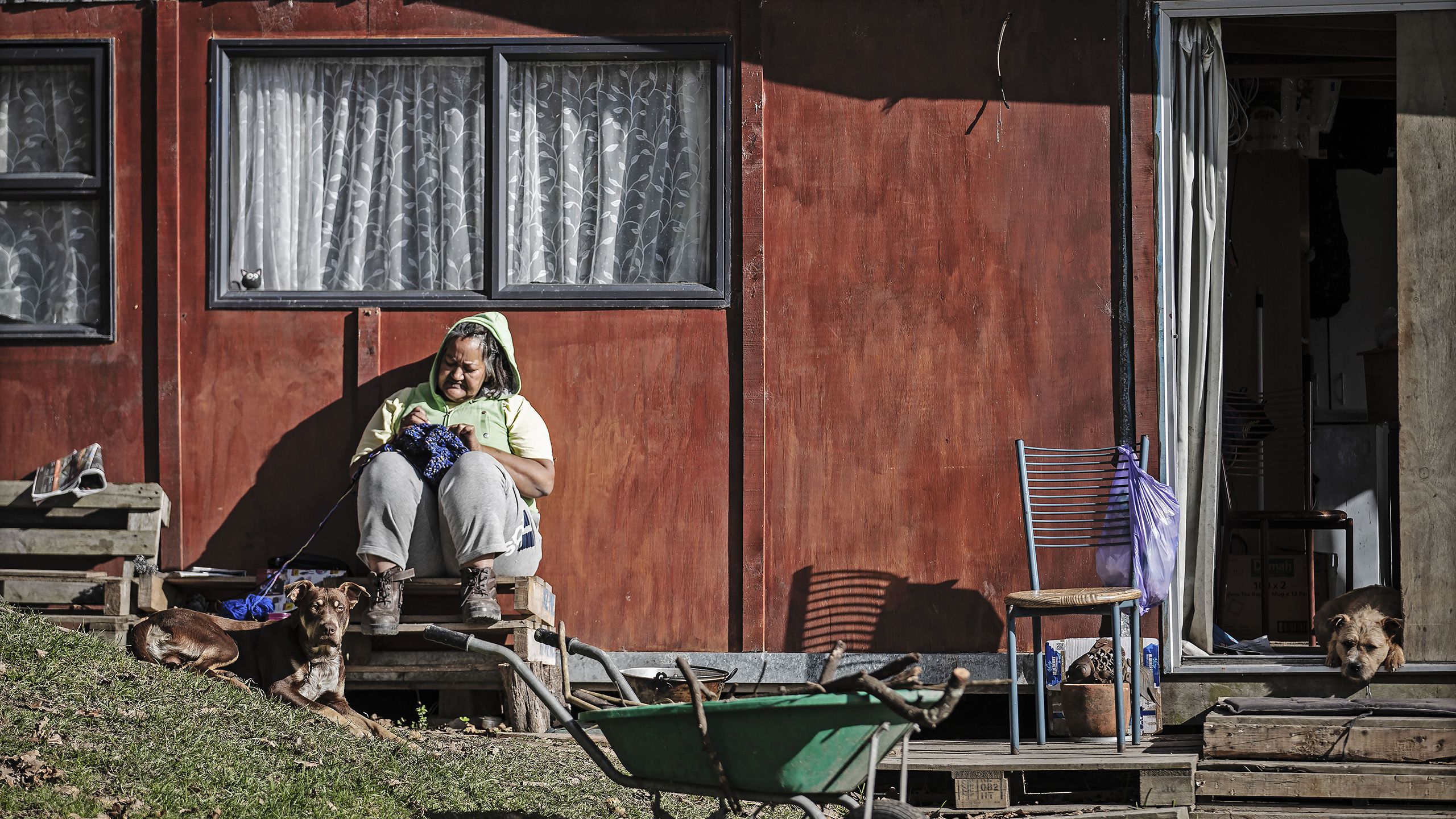 woman sitting with her dog outside her home