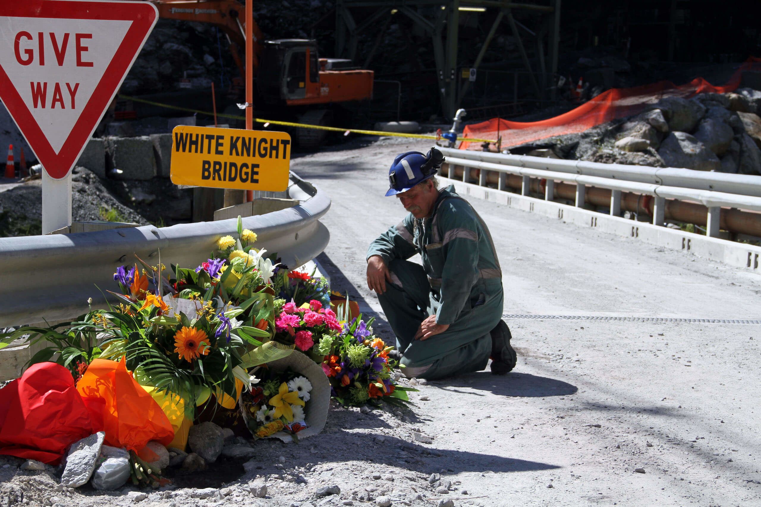 A miner laying down flowers at the White Knight Bridge near the entrance to the Pike River mine after the family visit to there on Saturday, to the site where 29 miners died when trapped underground, Greymouth, New Zealand, Monday, November 29, 2010. Credit: NZPA