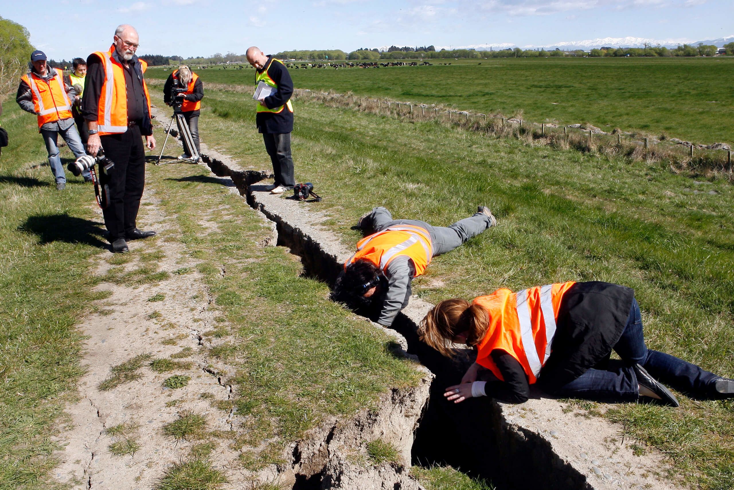 Engineers from ECAN and other areas in NZ have been inspecting the Waimakariri River stopbanks on the coast side of State Highway 1 after Sep 4 M7.1 earthquake. TV crew film the inside of the crack on the stopbank while John McCombe (photographer) looks on. Credit: Stacy Squires / Stuff