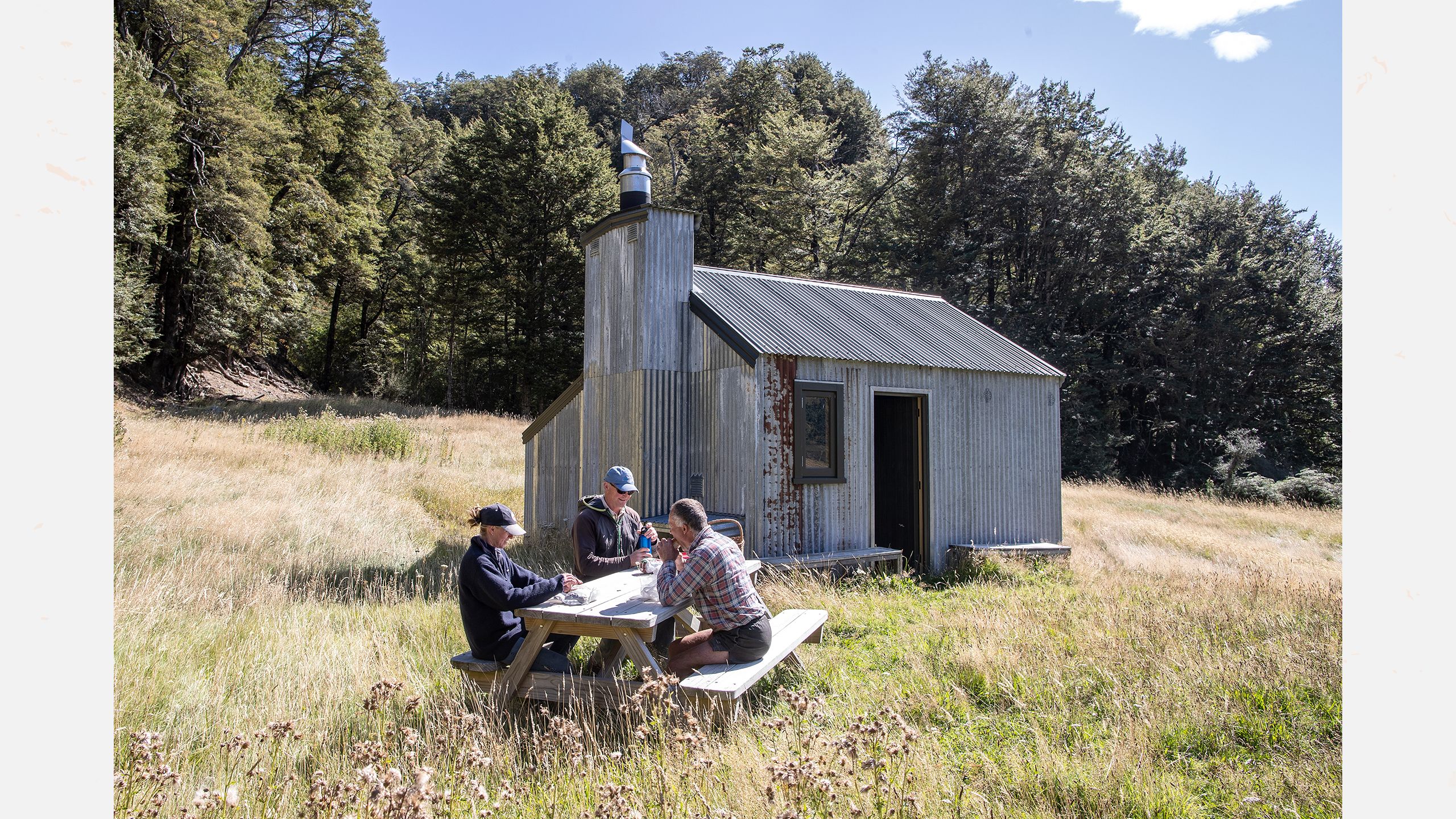 Shepherds Holly Addison and John Templeton (JT) have lunch with Philip Todhunter (middle) at a hunters hut before heading on a sheep muster.