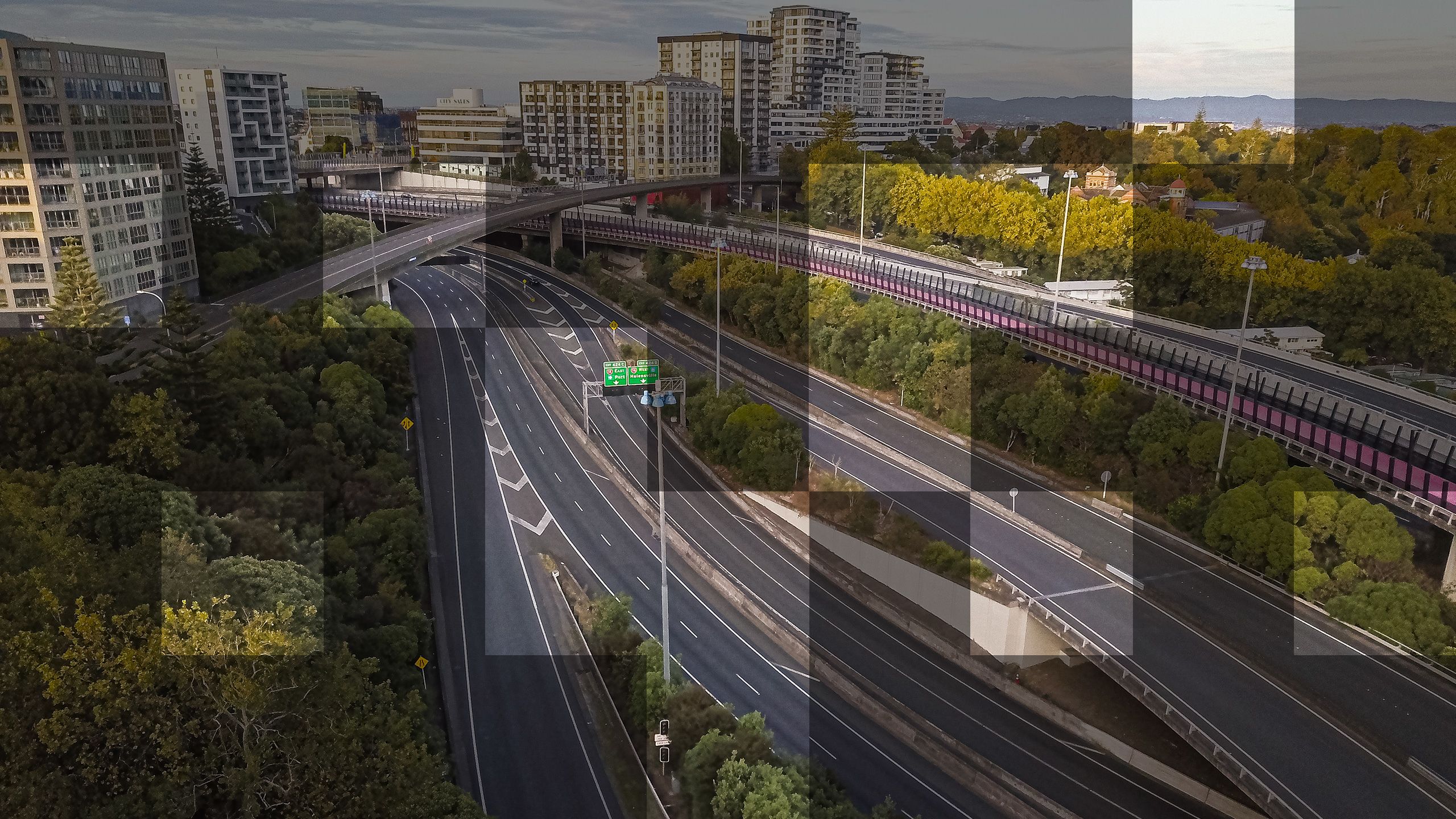 Same photo of the motorway but with some squares in a grid pattern revealing a lighter version of the same image.