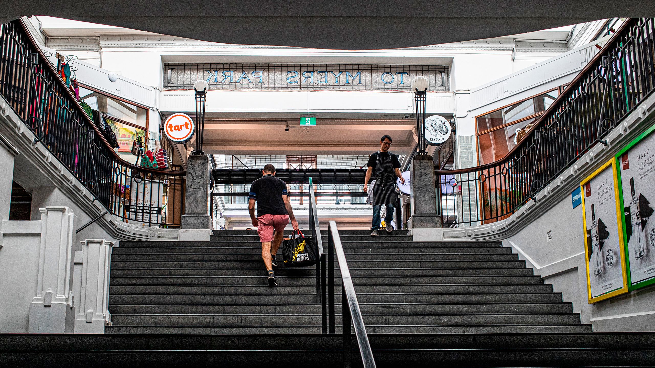 One man walking up and one man walking down the stairs at St. Kevins Arcade.