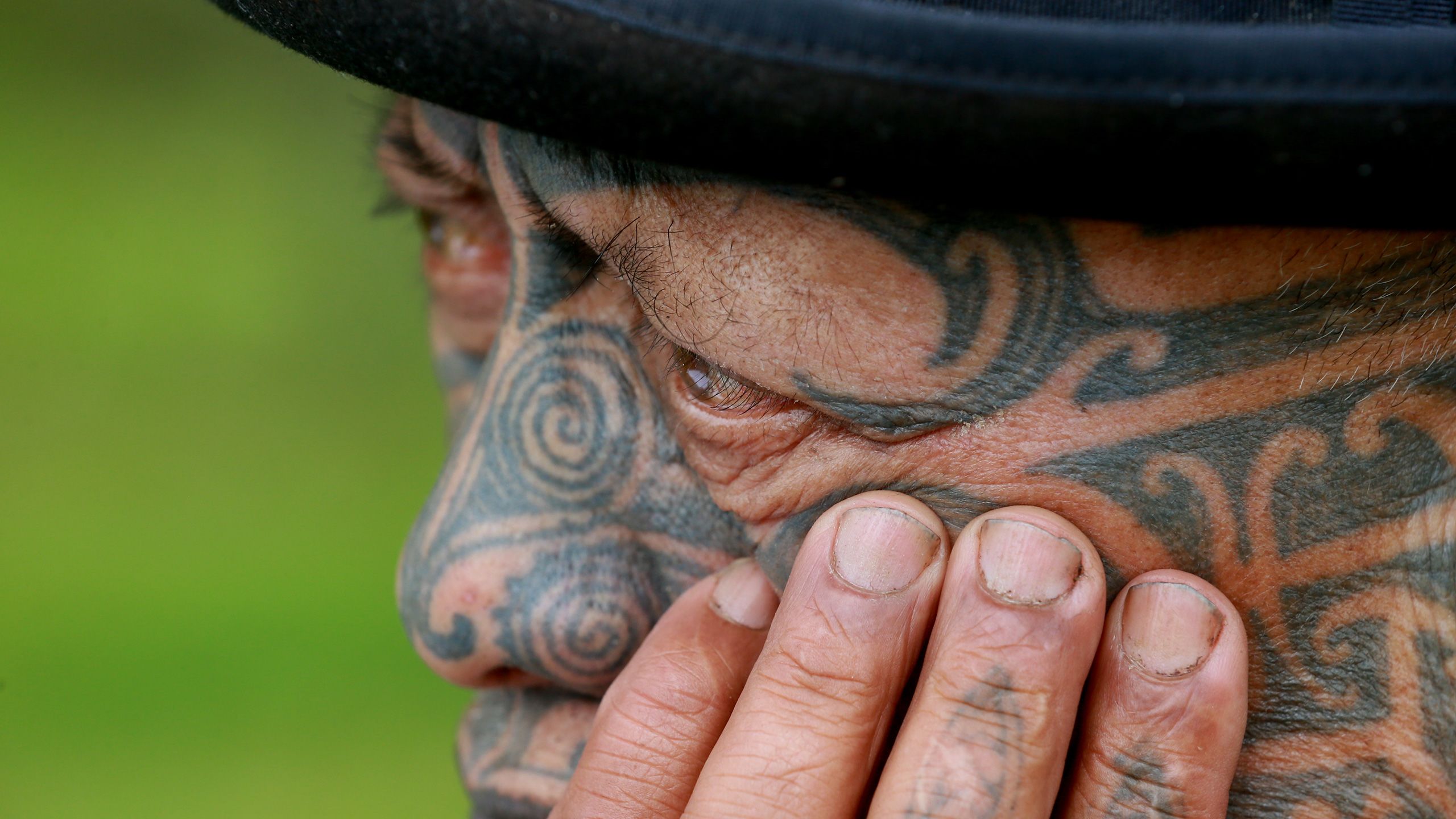 Close-up of Tame's face, hand on his cheek, looking pensive.