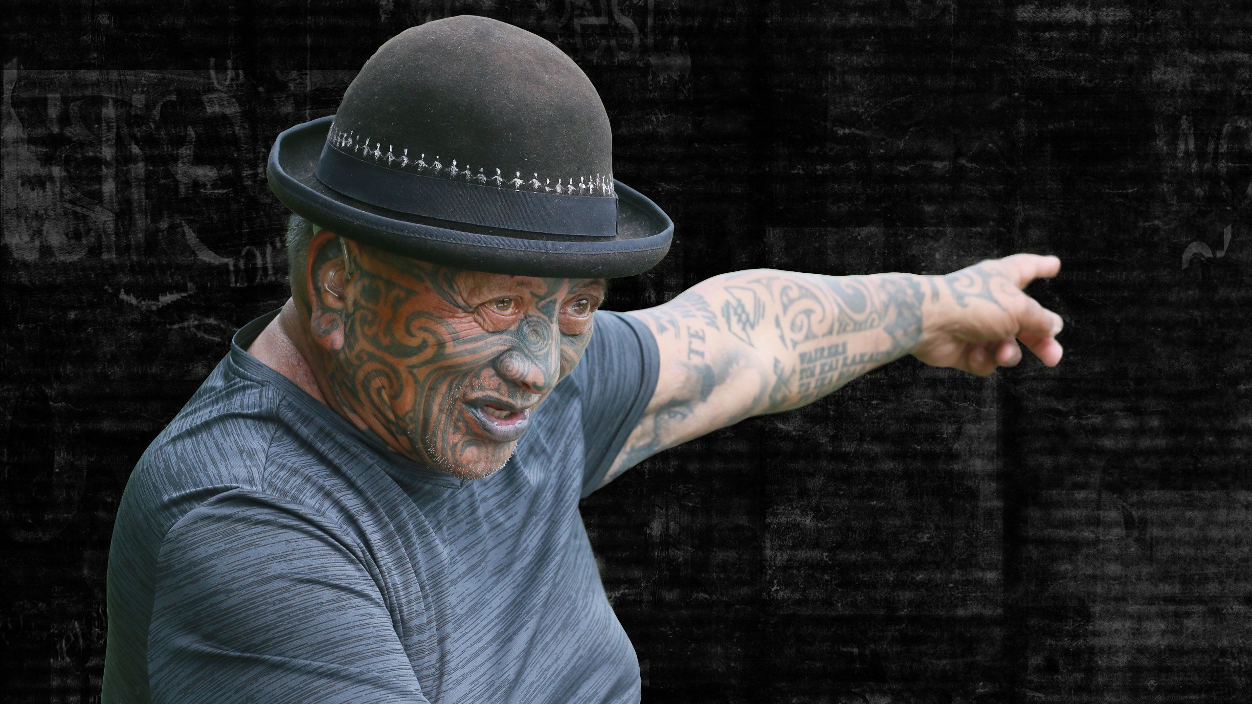 Tame outside his home, with his left arm raised with his finger pointing. Background turns to dark, newspaper texture.