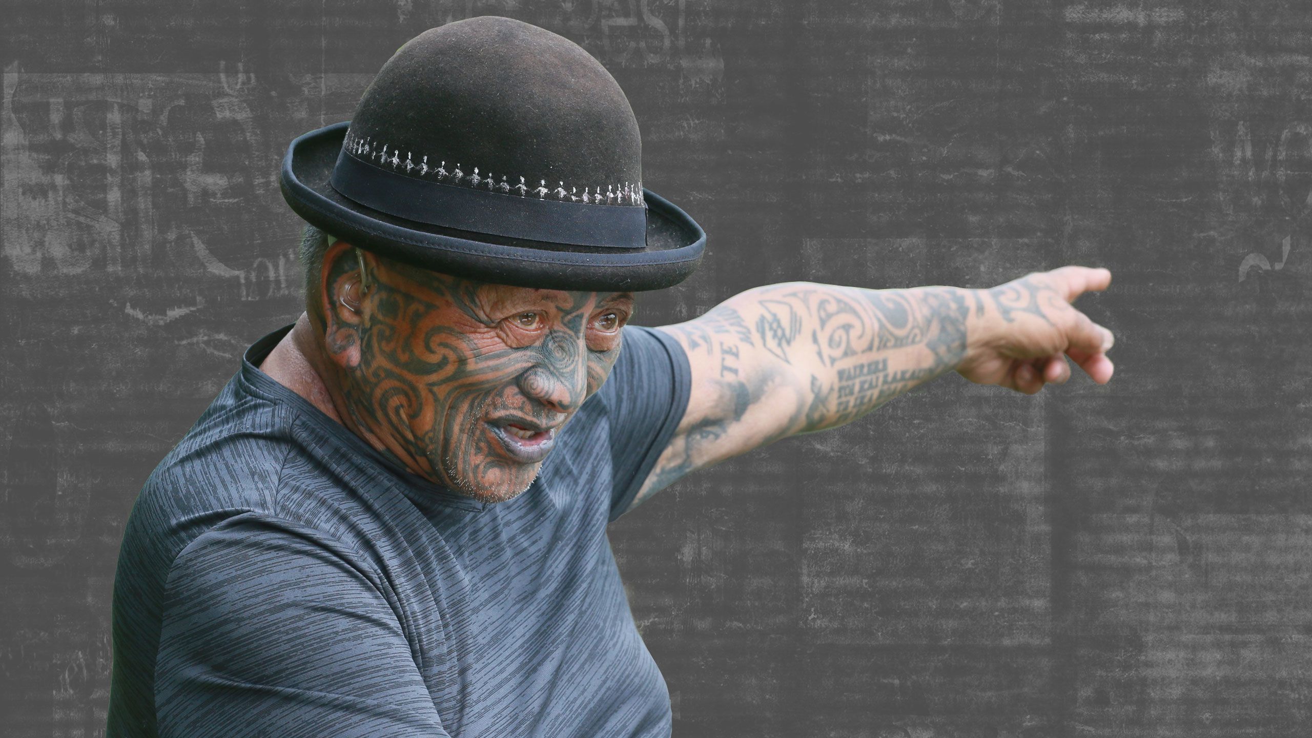 Tame outside his home, with his left arm raised with his finger pointing.