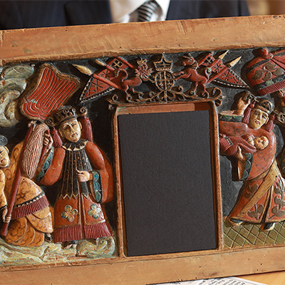 Painted carving of Chinese figures in ornate clothing