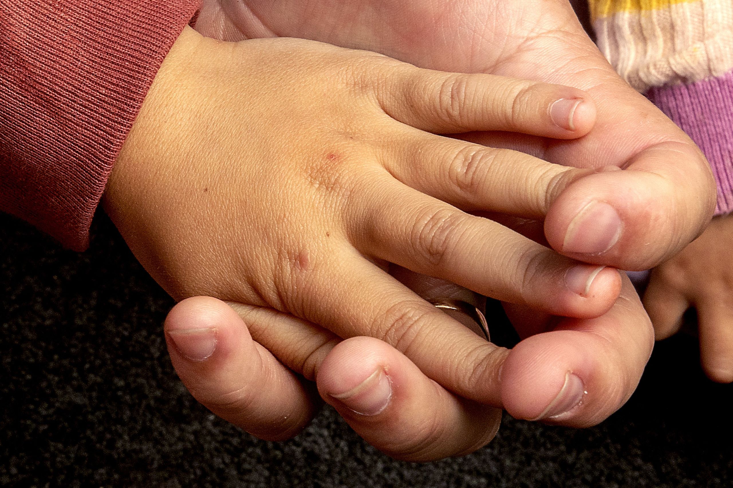 Close up of father and child's hands.