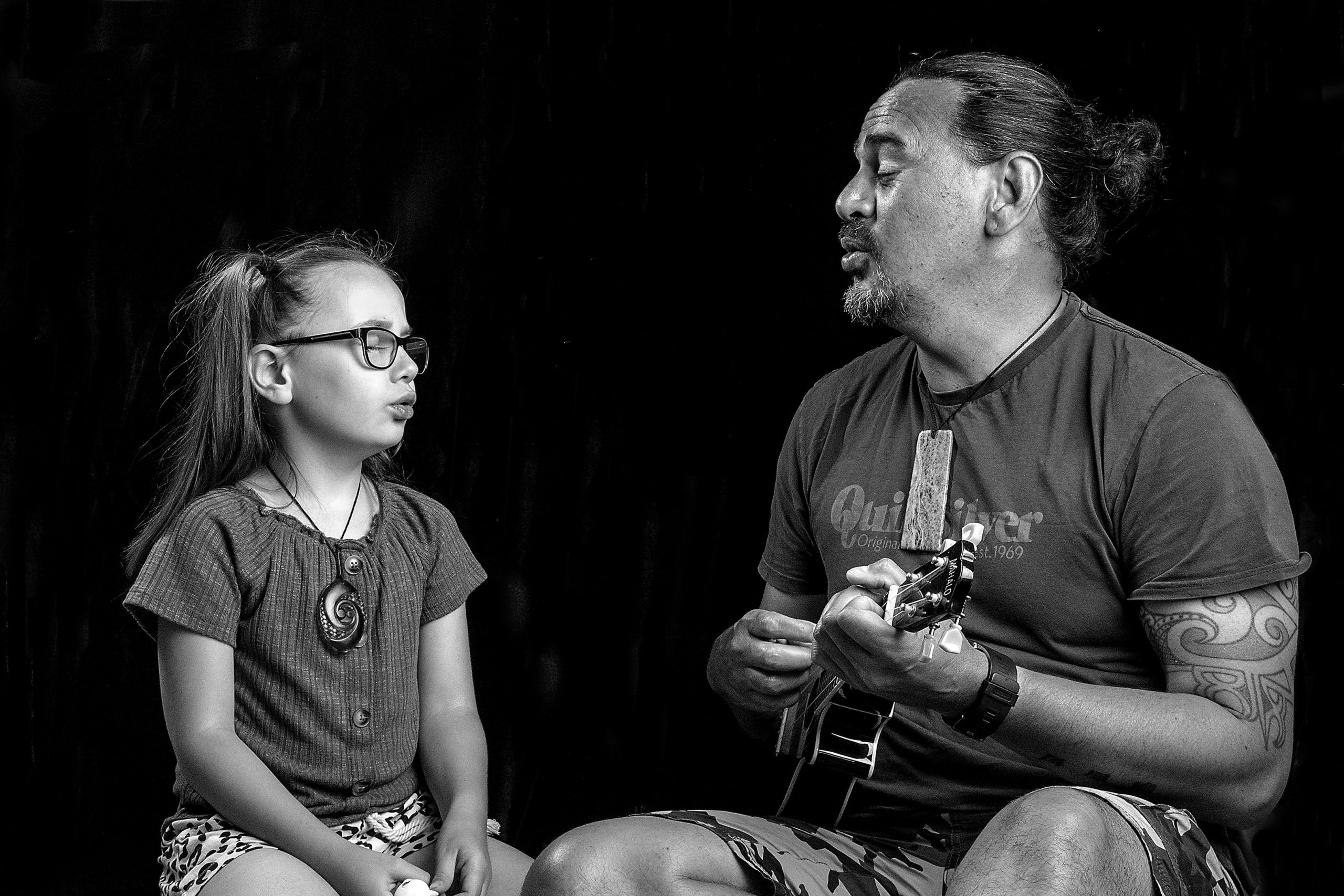 Jamie McCaskill playing an instrument and singing with his daughter.