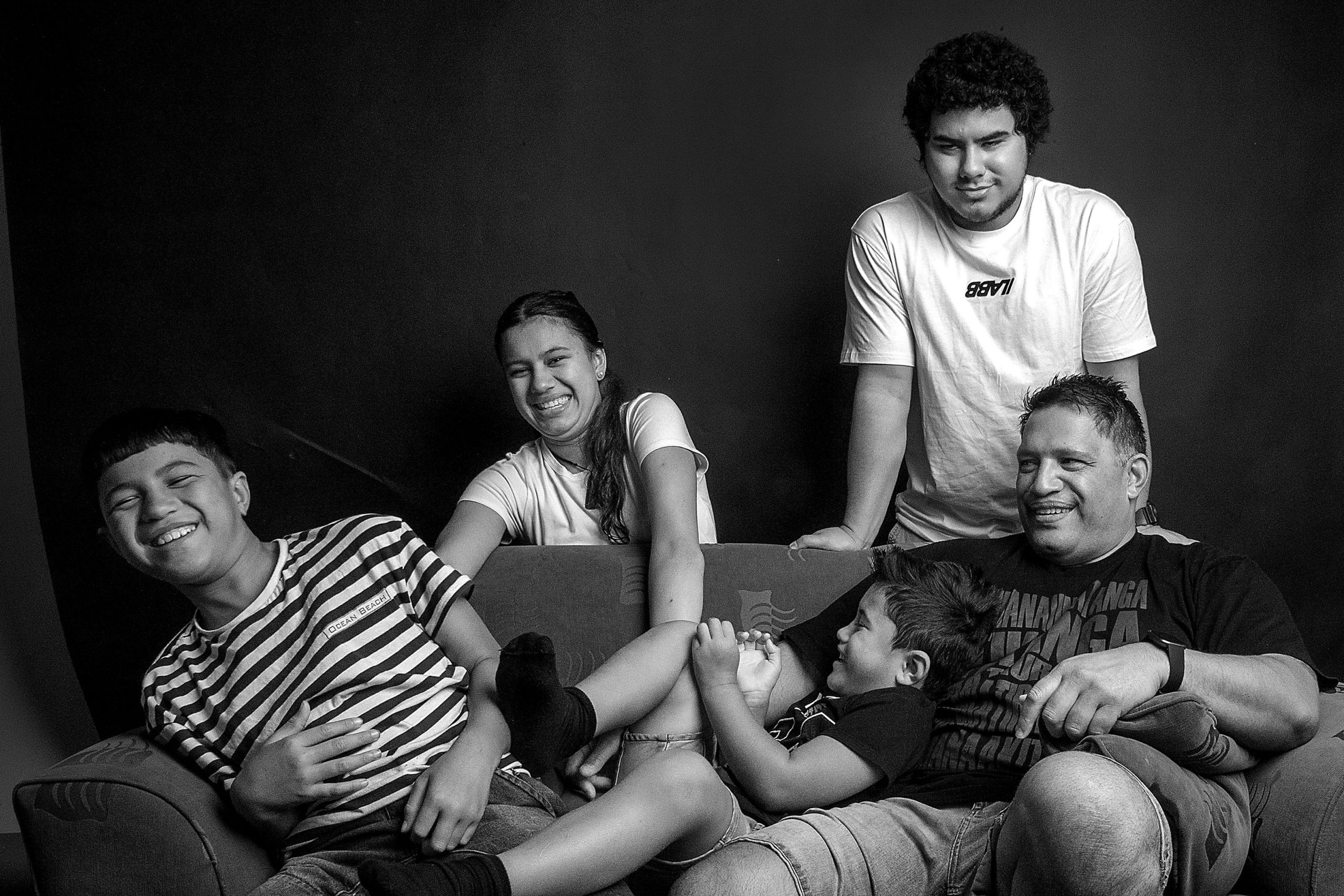 Corey Woon and his children gathered around a couch.