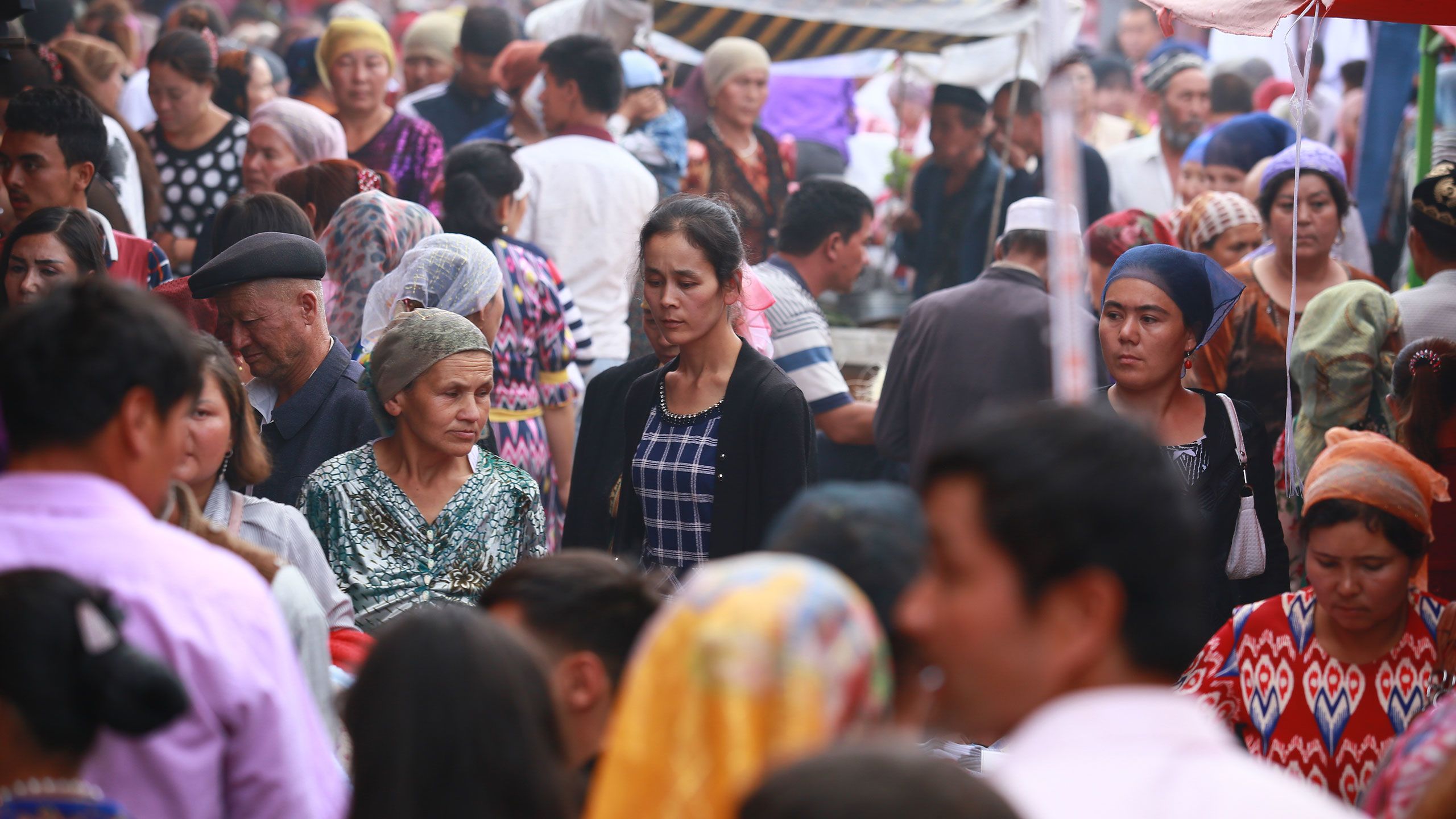 Uygur people walk out of a bazaar