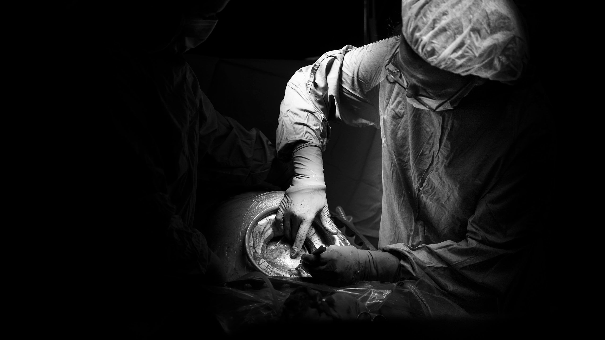 The surgeon has now created a round hole with support for the baby to be birthed through. The head of the baby can be seen inside the hole.