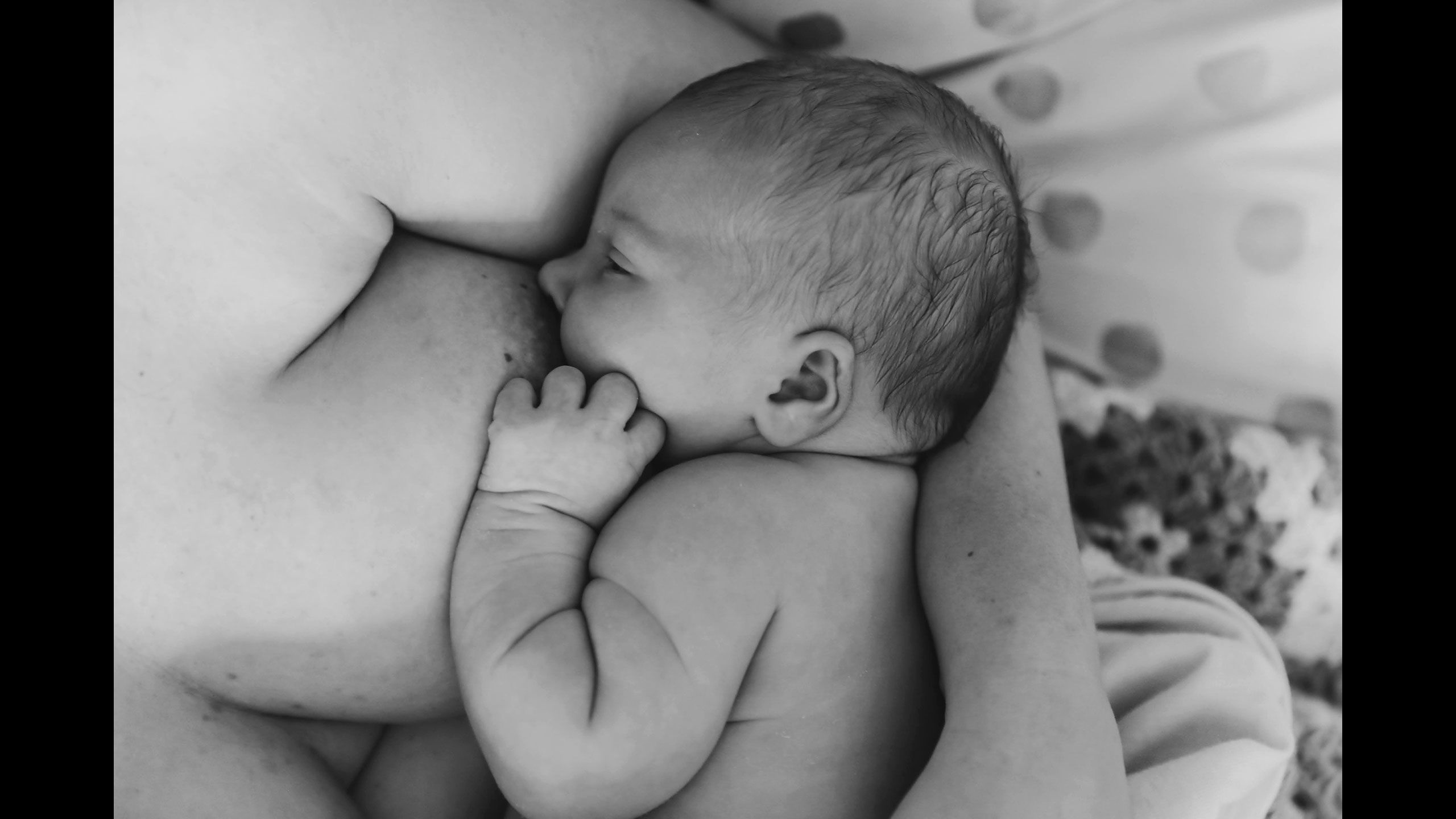 A very close-up view of Jessica breastfeeding Hazel.