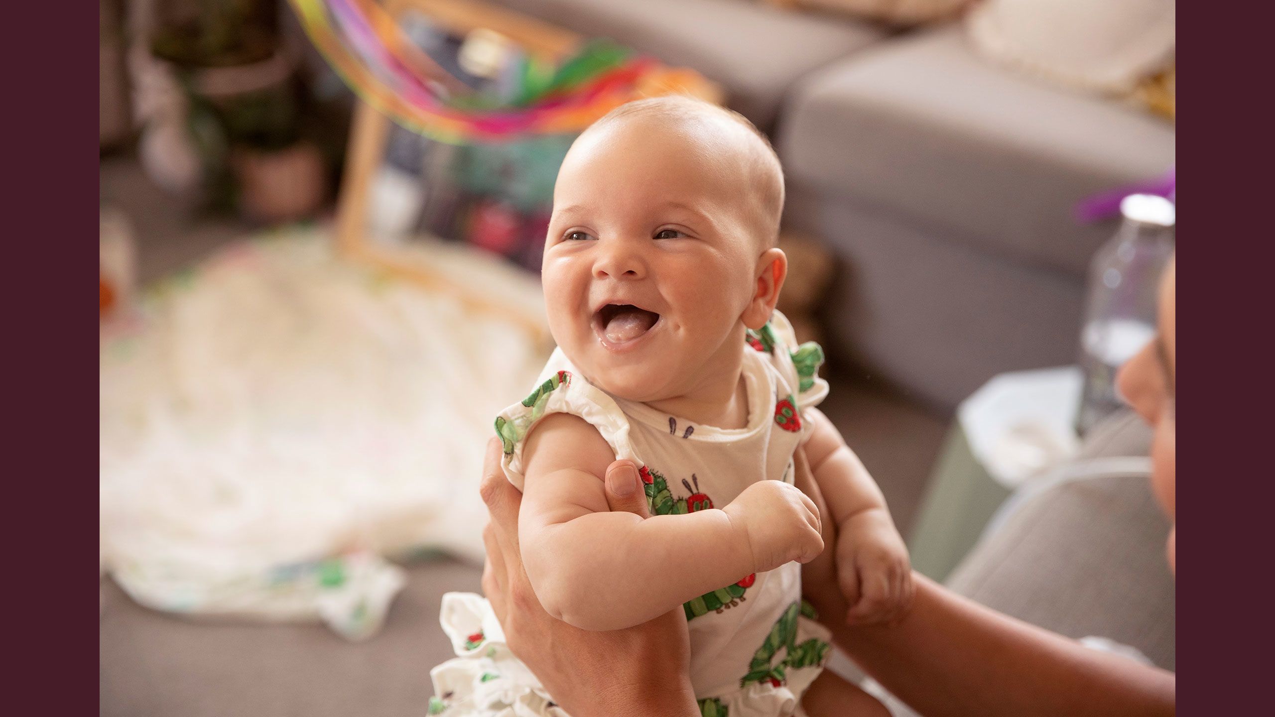 An older Hazel smiling happily in her mum's arms.