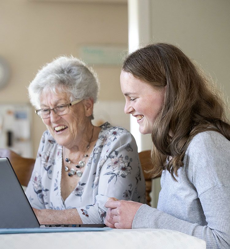 Charlotte and her nana sit looking at a laptop screen together.