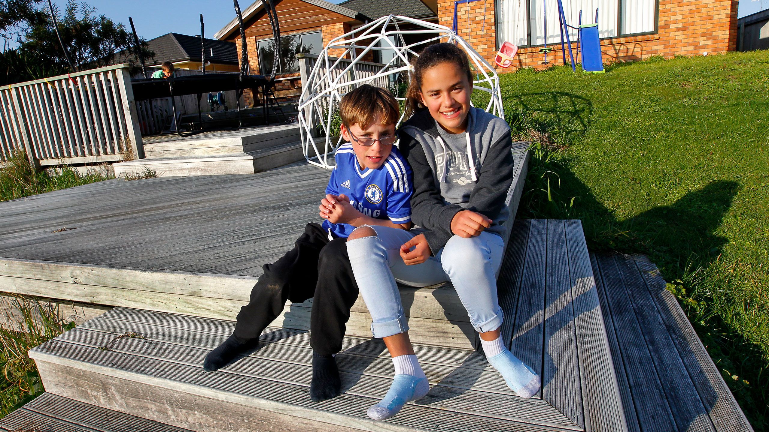 Cullen and Brooke as older children sitting together on their patio.