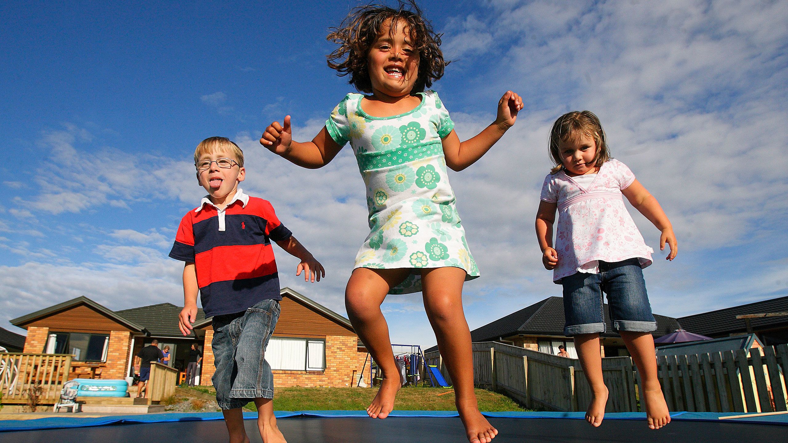 Cullen and Brooke play with a friend on a trampoline.