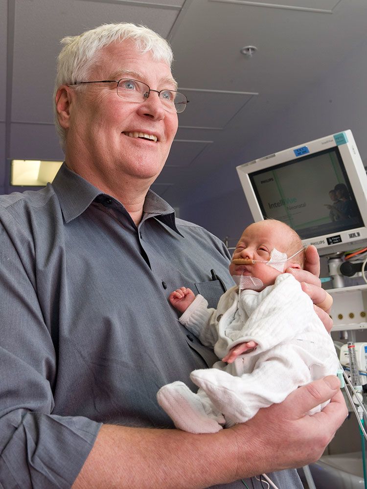 Vaughan Richardson holding a premature baby in his arms when he worked at NICU.