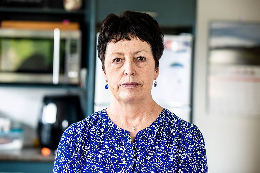 Kerryn looks directly to camera, unsmiling and serious.